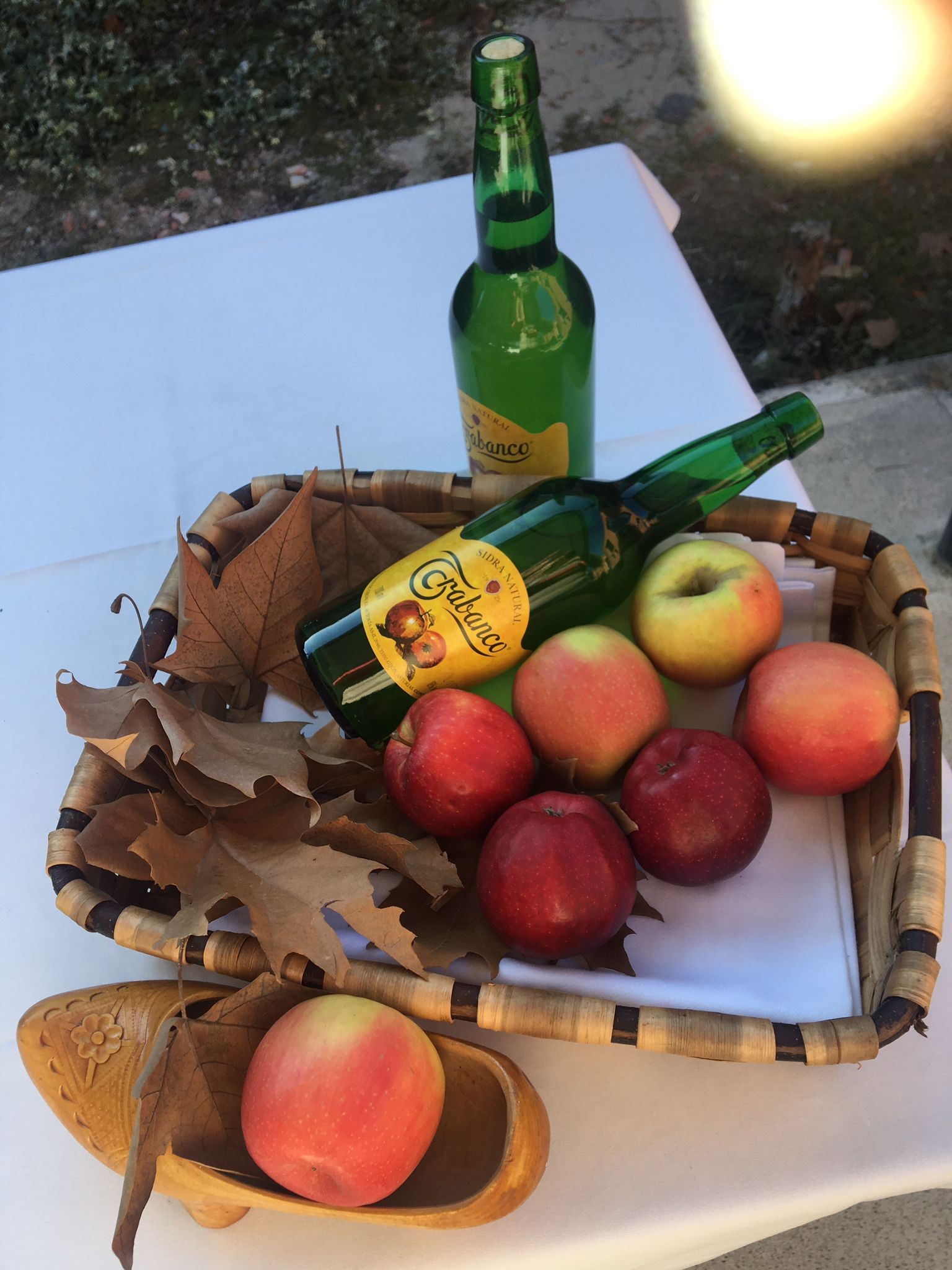 Botella de sidra y cesta de manzanas
